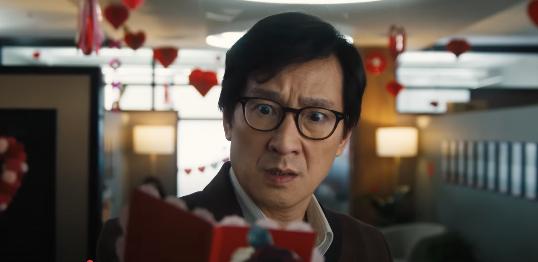 film still showing a man looking shocked at a notebook