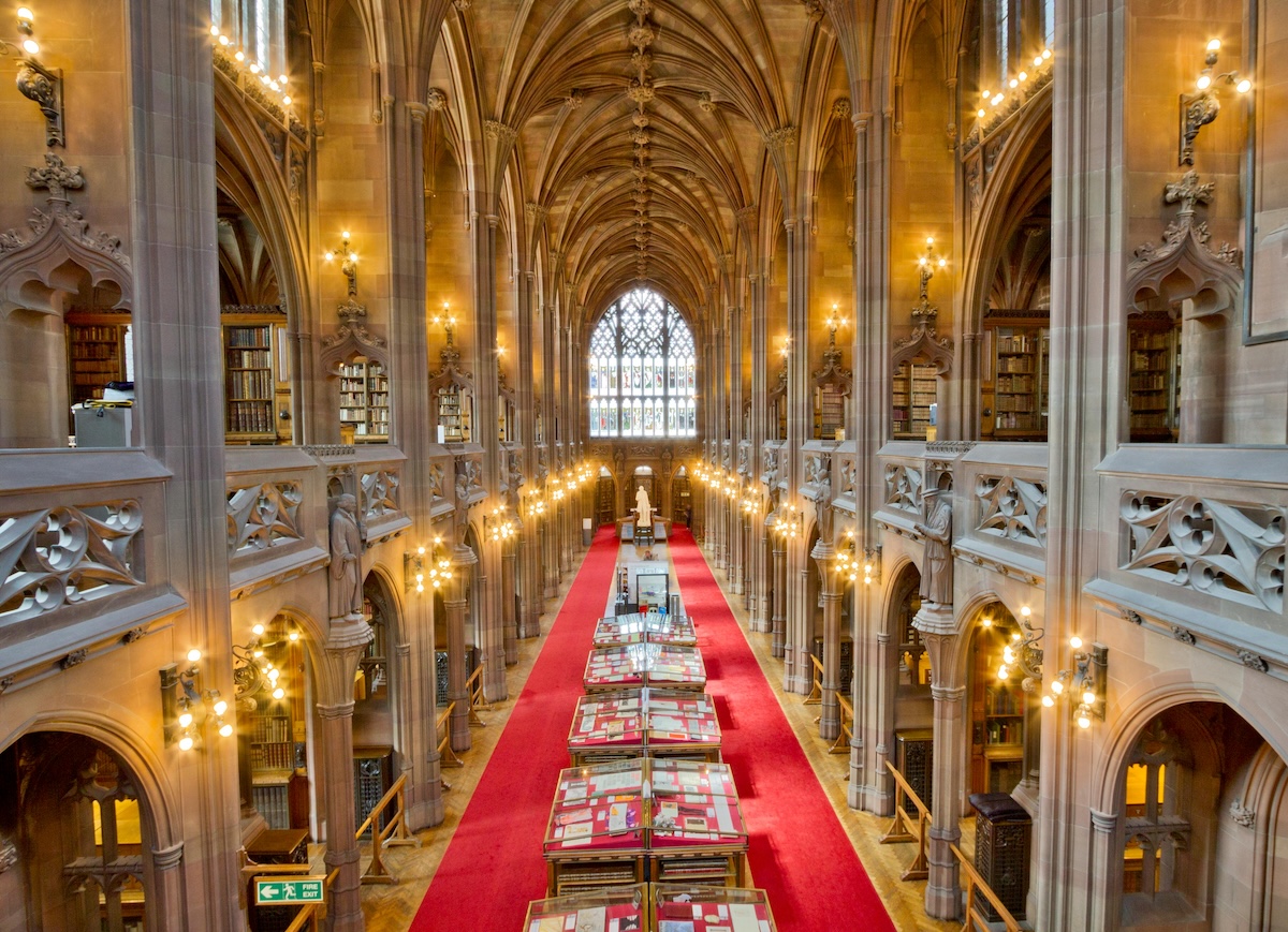 Long corridor with vaulted ceiling and stained glass window of John Rylands Library